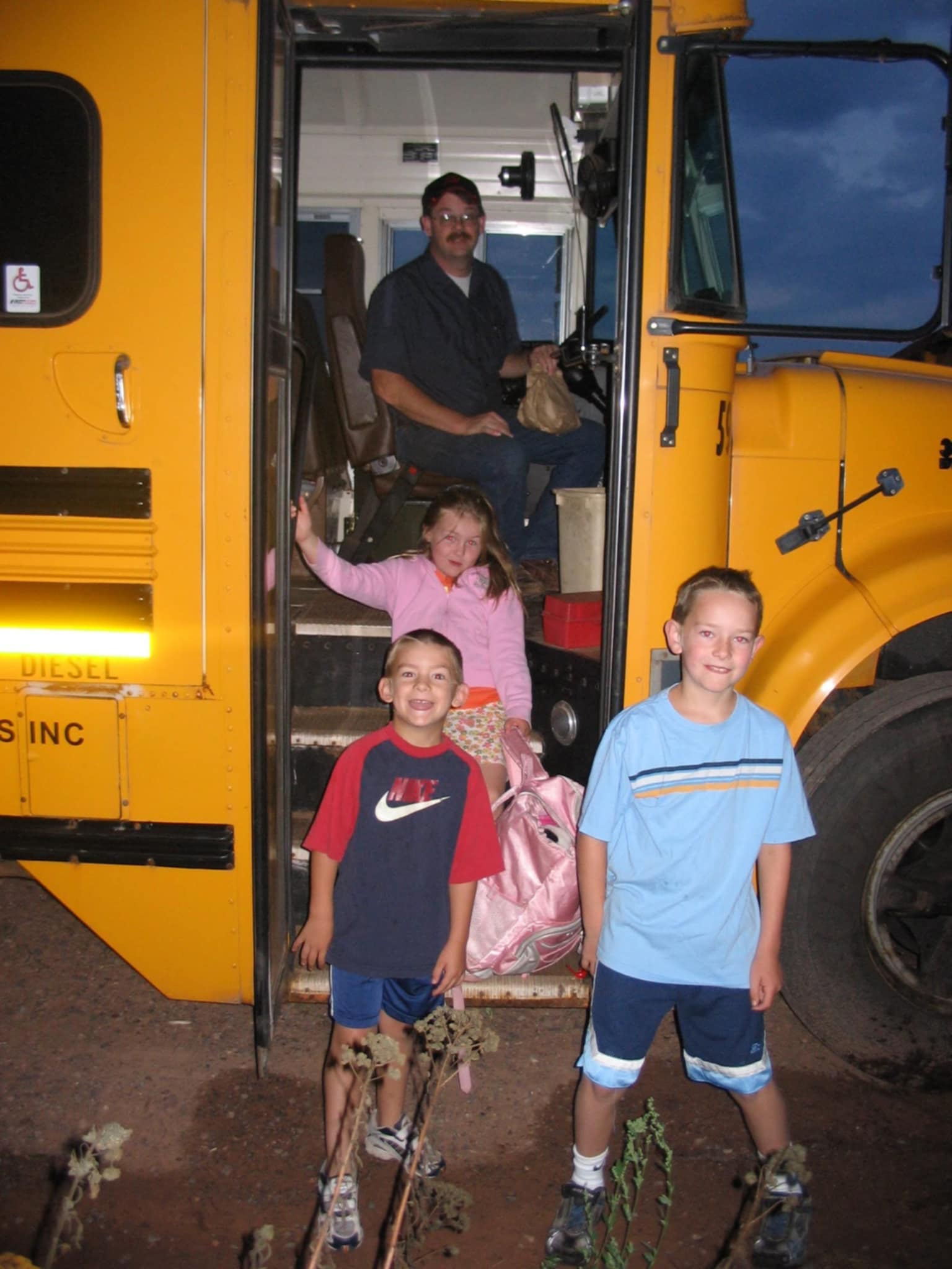 The founder as a child with siblings getting off their dad's school bus